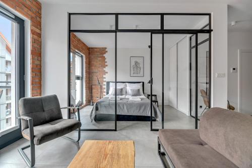 a bedroom with a bed and a couch at Downtown Apartments Aura III in Gdańsk