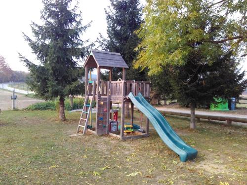 a wooden playground with a slide and a ladder at Apartmán na farmě u koní in Milešov