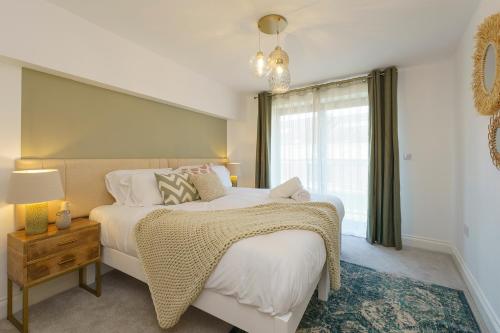 Evergreen - 2 Bed Luxury Apartment by Mint Stays في بريستول: غرفة نوم بسرير كبير ونافذة