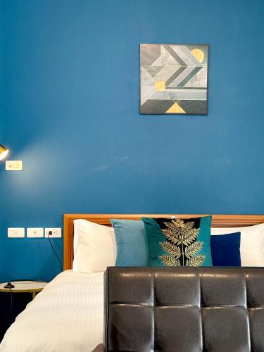 a bedroom with a bed with a blue wall at 艾迪行旅民宿 in Ruisui
