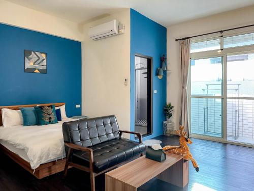 a bedroom with a bed and a chair and a couch at 艾迪行旅民宿 in Ruisui
