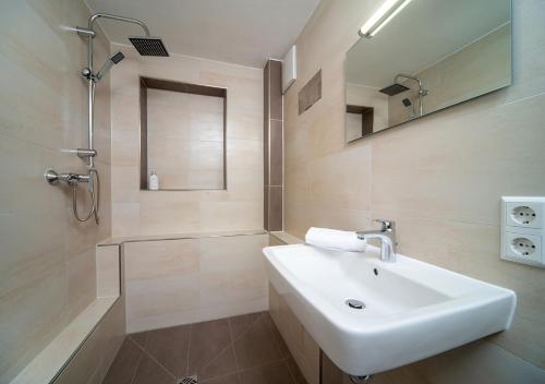 a bathroom with a sink and a shower and a mirror at Hotel Mohren in Ochsenhausen