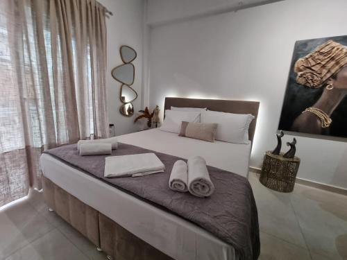 1 dormitorio con 1 cama grande y toallas. en Acropolis Museum Suite, en Atenas