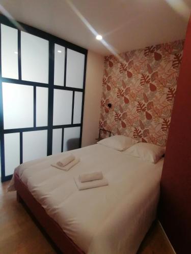 une chambre avec un lit avec deux serviettes dessus dans l'établissement L'étoile de mer - Les remparts, à Gravelines