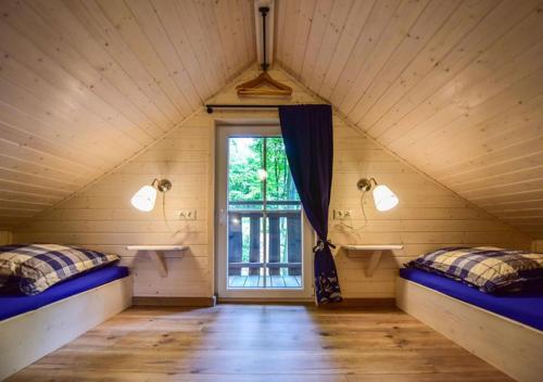 Pokój na poddaszu z 2 łóżkami i oknem w obiekcie Baumhäuser- Nordic Ferienpark Sorpesee w mieście Sundern (Sauerland)