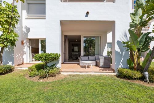Casa blanca con patio y sofá en Stunning blue lagoon apartment in Estepona M12, en Estepona