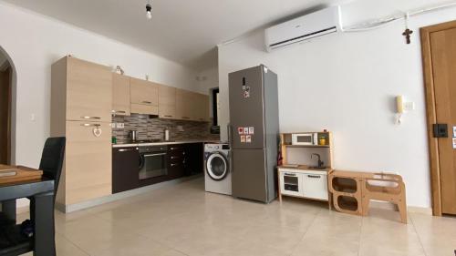 eine Küche mit einem Kühlschrank, einem Herd und einer Mikrowelle in der Unterkunft Cristina Home in St Paul's Bay