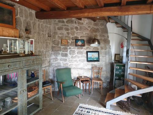 una stanza con tavolo, sedie e un muro in pietra di Torrebeatrice a Bagnaia