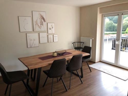 a dining room with a wooden table and chairs at Fiete in Ammerich