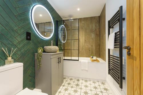 a bathroom with a tub and a sink and a mirror at Euphorbia - 1 Bedroom Luxury Apartment by Mint Stays in Bristol