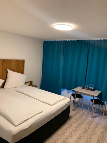 a bedroom with a bed and a table with chairs at Hotel am Bahnhof in Feldkirch