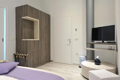 1 dormitorio con 1 cama, TV y armario en Apartments & Rooms Lavandula Exclusive, en Zadar