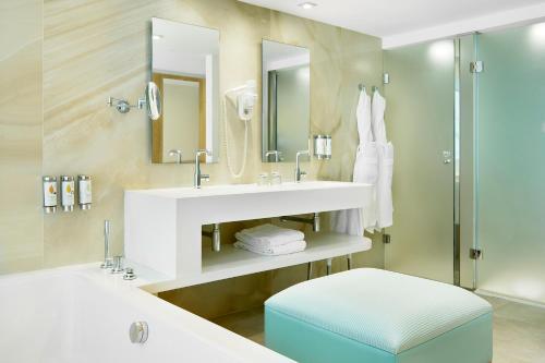 a bathroom with a sink and a mirror and a stool at Iberostar Selection Playa de Palma in Playa de Palma