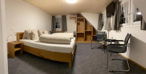 a bedroom with a bed and chairs in a room at Hotel Landgasthaus Neues Bild, Eggerstanden in Appenzell