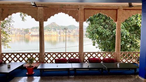 a room with a large window with a view of the water at Radhika Palace Hotel in Pushkar
