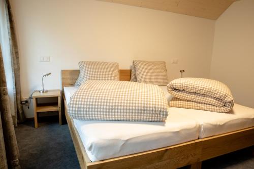 a bedroom with two beds with checkered pillows at Hotel Landgasthaus Neues Bild, Eggerstanden in Appenzell