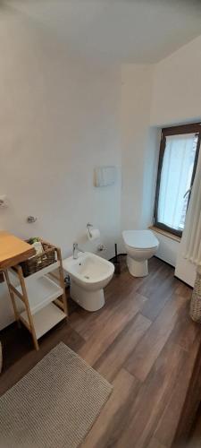 een badkamer met 2 toiletten en een wastafel bij Al vicolo del Gallo MONOLOCALE in Varallo