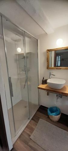 W łazience znajduje się szklana kabina prysznicowa i umywalka. w obiekcie Al vicolo del Gallo MONOLOCALE w mieście Varallo