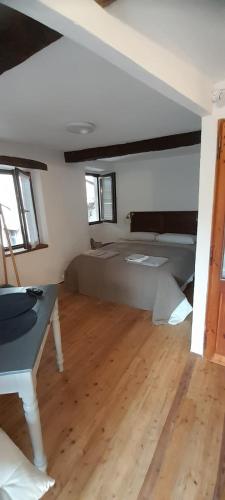 a bedroom with a bed and a table in it at Al vicolo del Gallo MONOLOCALE in Varallo