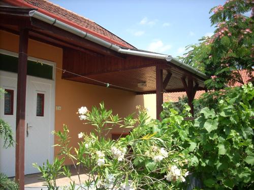 a porch of a house with a white door at Abádi Karmazsin Ház in Abádszalók