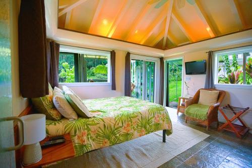 a bedroom with a bed in a room with windows at The Inn at Kulaniapia Falls in Hilo