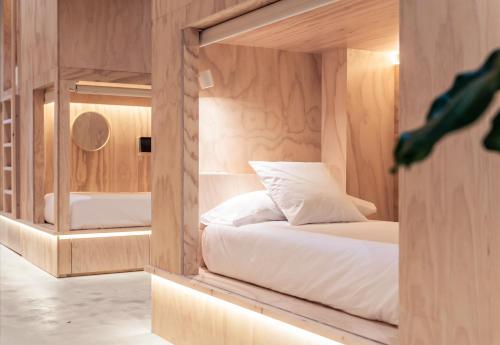 um pequeno quarto com uma cama e um espelho em Colo Colo Hostel - Single Private Beds em San Sebastián
