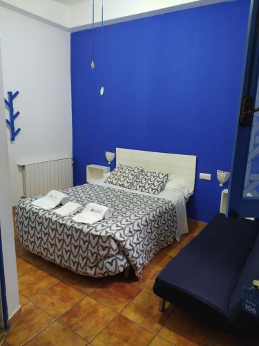 a bedroom with a bed with a blue wall at The Dreamers&Co in Córdoba