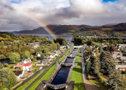 an aerial view of a town with a rainbow at Carn A Chuilinn House in Fort Augustus