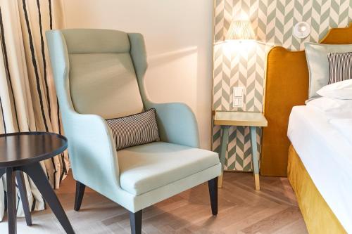 a chair in a room next to a bed at MAXX by Steigenberger Vienna in Vienna