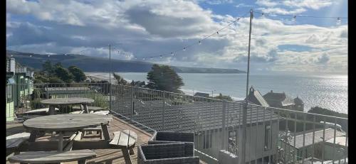 a balcony with a table and chairs and a view of the water at Barmouth Pet-Friendly 2-Bed Caravan with Sea View in Barmouth