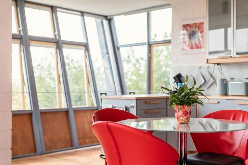 uma cozinha com cadeiras vermelhas e uma mesa com uma planta em Wunderschöne Ferienwohnung am Glatzenstein im Nürnberger Land 