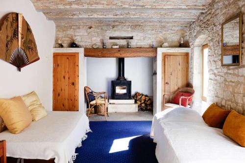 - 2 lits dans une chambre avec cheminée dans l'établissement La Bergerie à Cratoule, Domaine Les Musarts, à Issirac