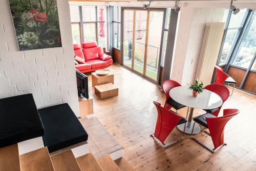 uma sala de estar com uma mesa e cadeiras e um sofá em Wunderschöne Ferienwohnung am Glatzenstein im Nürnberger Land 