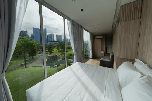 a bedroom with a white bed and a large window at Garden Pod at Gardens by the Bay in Singapore