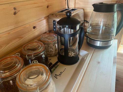 a coffee maker sitting on a counter next to jars at The Hobbit Hole in Zelah