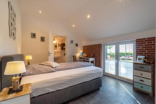 um quarto com uma cama grande e uma parede de tijolos em Insel-Land-Hotel Michaelsen em Borkum