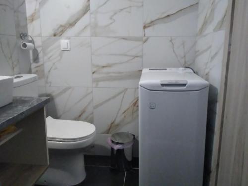 een witte badkamer met een toilet en een wastafel bij Κamares View (Αύρα) in Ayeranós