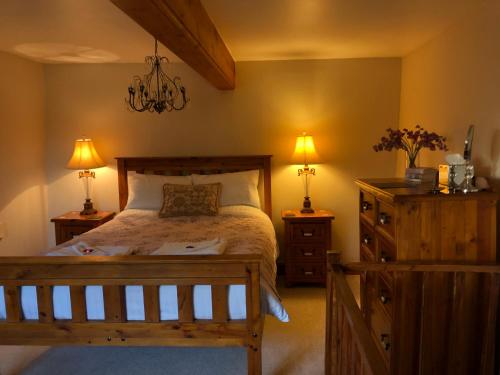 a bedroom with a bed with two night stands and two lamps at The Walnuts Country House in West Row