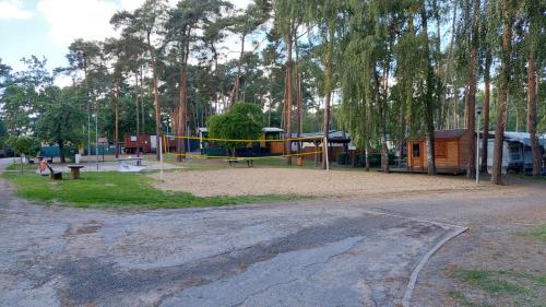 a park with a playground with a building and trees at Comtesse-Camping Plauer See in Brandenburg an der Havel