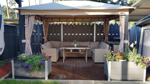 a gazebo with a couch and a table under it at Comtesse-Camping Plauer See in Brandenburg an der Havel
