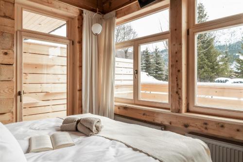 a bedroom with a bed with two windows at Villa Milimani - stuletnia, folk & butique, adults only in Zakopane