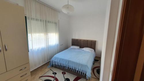 um pequeno quarto com uma cama e uma janela em La Casita em Tirana