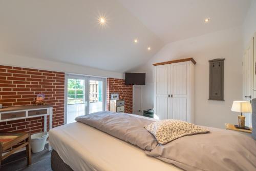 a bedroom with a bed and a brick wall at INSEL-LAND-HOTEL MICHAELSEN im November Morgen-Yoga u Sauna inkl in Borkum