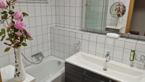 a bathroom with a sink and a vase with pink roses at Markt 9 Appartements Oberwiesenthal in Kurort Oberwiesenthal