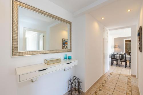a bathroom with a mirror and a sink and a hallway at L’Ancora Suite in Jávea