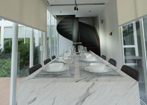 a dining room with a long table with wine glasses at Garden Pod at Gardens by the Bay in Singapore