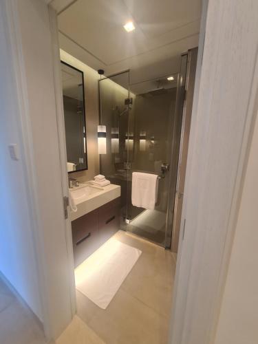 a bathroom with a shower and a sink and a mirror at Luxury sea view Apartment In Address Hotel Fujairah in Fujairah