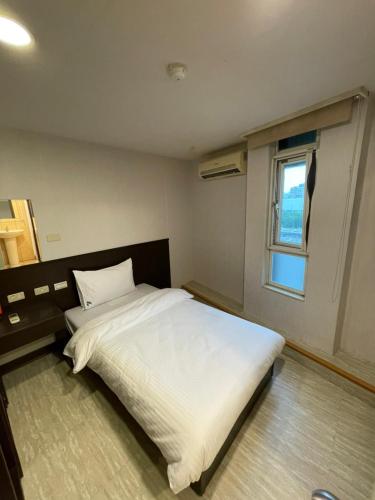 a bedroom with a white bed and a window at 苓旅-站前 Lin Inn TMS in Taipei