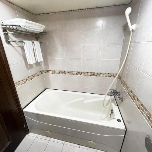 a white bath tub in a bathroom with a sink at 苓旅-站前 Lin Inn TMS in Taipei