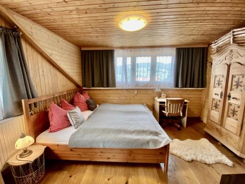 a bedroom with a bed in a wooden room at Chalet Almblick in Fischbach